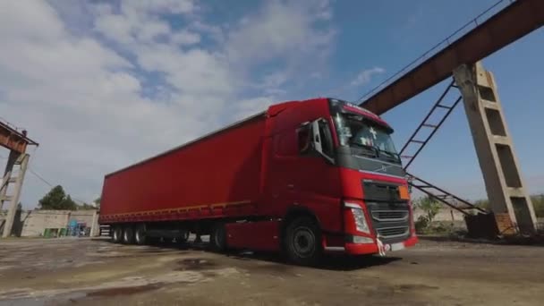 Červený náklaďák s červeným přívěsem jede za jasného slunečného dne do skladu — Stock video
