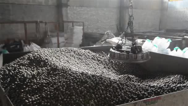 Grue électromagnétique avec billes métalliques, Grand bâtiment industriel avec grues électromagnétiques mobiles, production de billes, fabrication de roulements. — Video