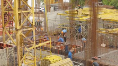 İnşaat alanında çalışanlar. İnsanlar yeni bir evin inşaatı üzerinde çalışıyorlar. Güçlendirilmiş Beton İnşaat