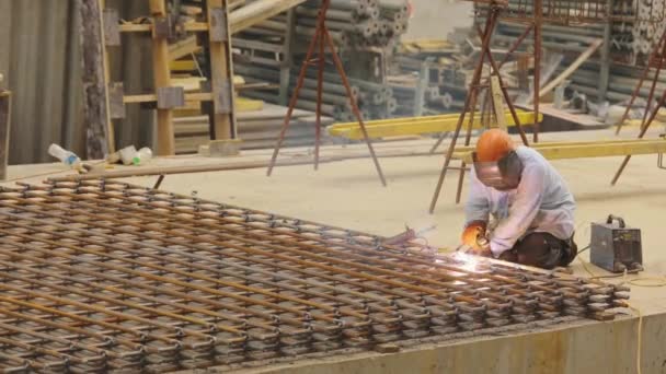 Svetsning metallkonstruktion. En svetsare svetsar ihop en metallkonstruktion. Byggsvetsare — Stockvideo