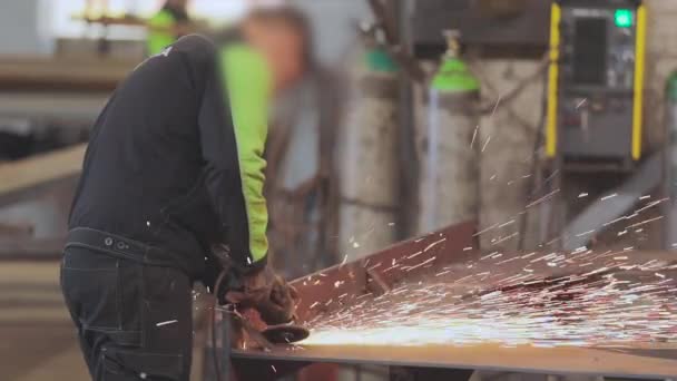 Människan arbetar som kvarn i en verkstad, ljusa gnistor från en kvarn — Stockvideo