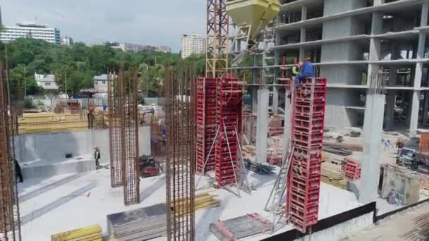 Werknemers op een bouwplaats. Constructie van gewapend beton. Bouw van een modern wooncomplex — Stockvideo