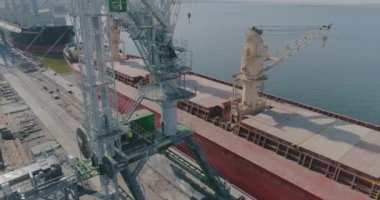 Limanın üzerinden kargo gemileriyle uçun. Liman vinçleri ve büyük kargo gemileri üzerinde uçuş büyük bir limanın genel planı
