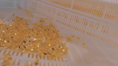 Bir ilaç fabrikasında ilaç üretimi. Taşıyıcı hat üzerinde turuncu tabletler.