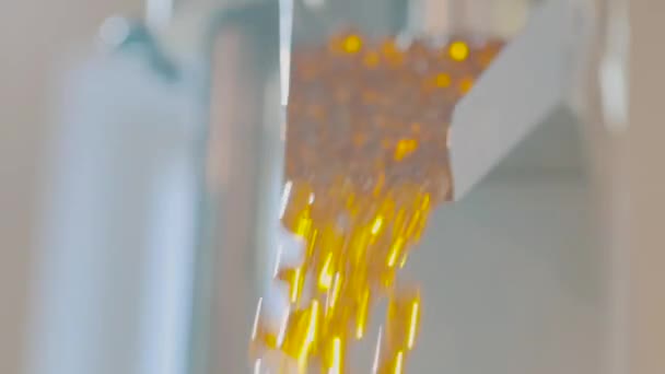 Capsules de gélatine sur la ligne de convoyeur, nombreuses capsules de gélatine jaune en production — Video