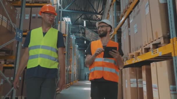 Dos ingenieros en un almacén moderno. Dos personas en el almacén están discutiendo algo. — Vídeo de stock