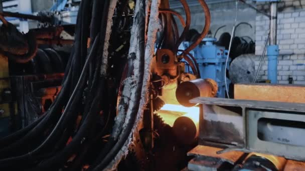 Movendo-se em uma fita de metal quente, rolamento de metal na produção, fase de produção de bolas, processo de produção em uma fábrica de laminação de metal, rolando através de rolos de metal espumante — Vídeo de Stock
