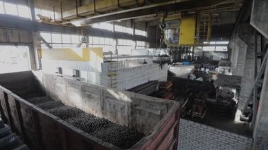 Metal topları olan elektromanyetik vinç, bir arabaya yükleniyor, top üretimi, bilye üretimi