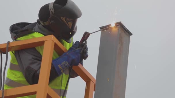 Soldador en el trabajo en cámara lenta, proceso de soldadura de metal. Soldadores en una obra de construcción — Vídeo de stock