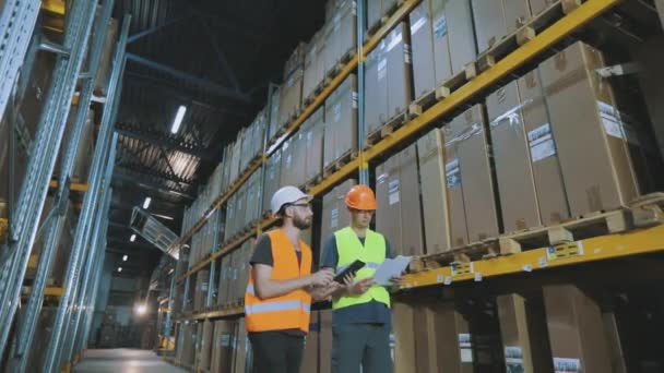 Dos trabajadores irán al almacén moderno. proceso de trabajo en el almacén. Fábrica moderna, interior industrial — Vídeo de stock