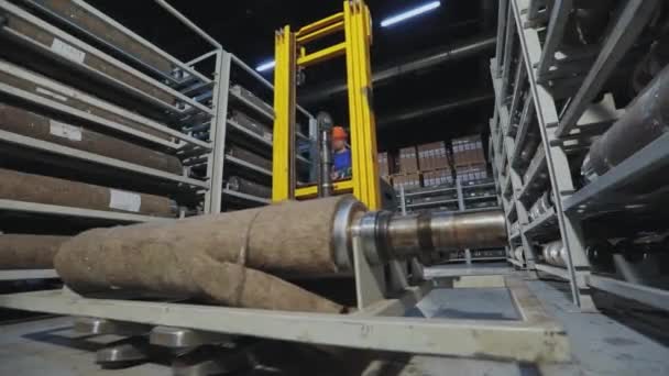 Современное производство обоев. Белый рабочий толкает укладчик с цилиндрической шахтой на складе. — стоковое видео