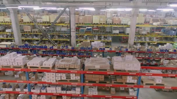 Span along shelves in a large warehouse. Shelves with goods in stock. Modern warehouse. Industrial interior — Stock Video