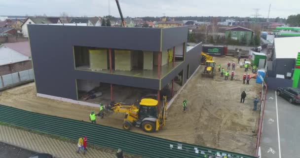 Edificio costruzione vista aerea. Escavatore in un cantiere, flusso di lavoro in un cantiere, persone che lavorano in un cantiere — Video Stock