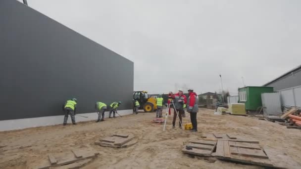 Építési terület, gépek egy építkezésen, emberek dolgoznak egy építkezésen — Stock videók