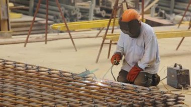 Bir kaynakçı metal bir yapıyı kaynak yapar. Kaynak metal yapımı. Güçlendirilmiş beton takviyesi