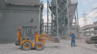 İnşaat alanında buldozer, şantiyede küçük sarı buldozer. Buldozer inşaat alanında çalışıyor.