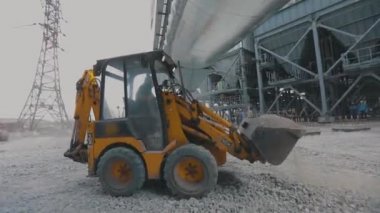 İnşaat alanında buldozer, şantiyede küçük sarı buldozer. Buldozer inşaat alanında çalışıyor.