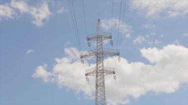 Elektrik taşıma hattı. Yüksek voltajlı kule. Elektrik direklerinin arka planında güzel bulutlar var. Elektrik taşıma hattı. Yüksek voltajlı kule