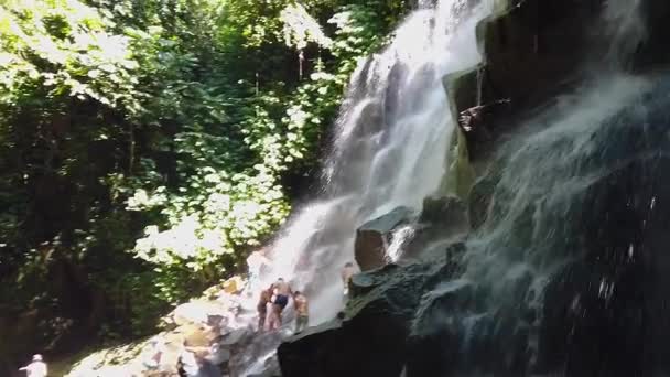 Ludzie kąpią się w wodospadzie, ludzie kąpią w górskim wodospadzie. Wielki piękny wodospad — Wideo stockowe