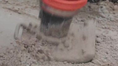 İnşaat alanında çalışan işçiler, rammer 'ı dolduran işçiler. Tamping toprağı