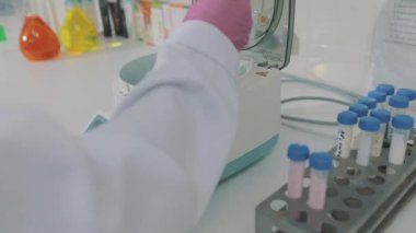 Maskeli laboratuvar asistanı. Laboratuvar çalışanı. Laboratuvarda çalışan bir kadın.