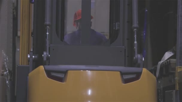 Gaffeltruck i ett lager närbild, en man som kör en modern gaffeltruck — Stockvideo