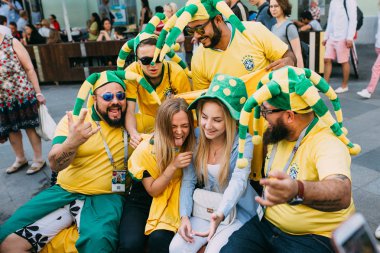 Moskova, Rusya - Haziran 2018 A grup Brezilyalı futbol taraftarları Dünya Kupası sırasında sokakta Rus kızlarla fotoğrafı