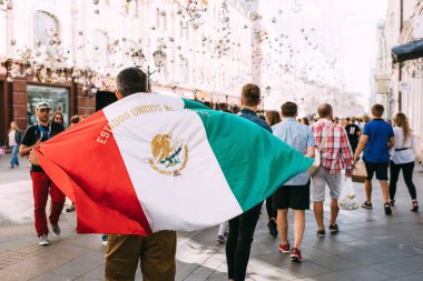 Moskova, Rusya - Haziran 2018 A fan Meksika bayrağı ile Dünya Kupası sırasında Moskova Merkezi Nikolskaya cadde boyunca yürüyor