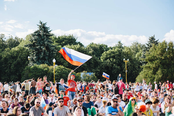 МОСКВА, РОССИЯ - ИЮНЬ 2018 Футбольный фанат размахивает российским национальным флагом в толпе во время чемпионата мира

