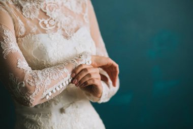 Bir güzel dantel beyaz düğün vintage elbise yakın çekim, sabah hazırlık koluma üzerinde düğmeleri gelin eller tutturmak.