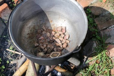 Gulaş güveç Romanya'da kırsal bir evin arka bahçesinde açık günlük ateşte kaynama dökme demir kazan