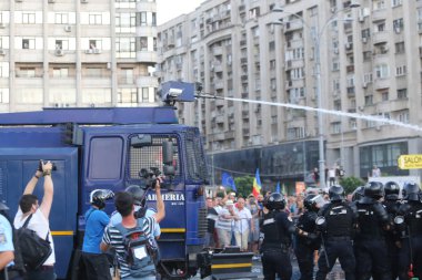 Bucharest, Romanya - 10 Ağustos 2018: Çevik kuvvet polisi kalabalığı dışında hükümet merkezi, Bükreş, Romanya, Cuma, 10 Ağustos 2018 protesto karşı bir su topu dağıtmak.