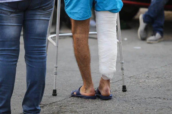 Details of the leg in a plaster cast of a patient going to the hospital with the help of a metal frame