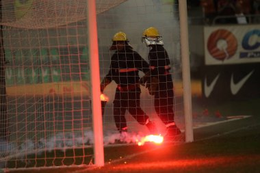 Bucharest, Romanya - 28 Temmuz 2018: İtfaiyeci çimde Dinamo Bükreş destekçileri tarafından ulusal Arena Stadyumu Dinamo ve Fcsb, arasında oyun sırasında atılan meşaleler söndürmek çalışır