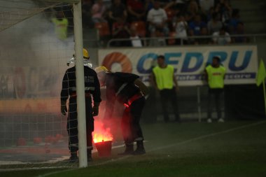 Bucharest, Romanya - 28 Temmuz 2018: İtfaiyeci çimde Dinamo Bükreş destekçileri tarafından ulusal Arena Stadyumu Dinamo ve Fcsb, arasında oyun sırasında atılan meşaleler söndürmek çalışır