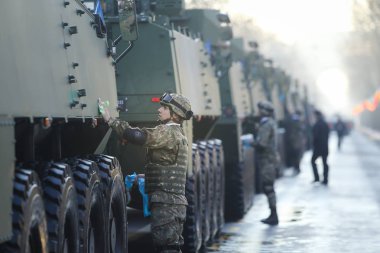 Bucharest, Romanya - 1 Aralık 2018: Romen askerlerin zırhlı araçlar Romanya Milli günü askeri geçit töreni önce temizlik yapıyorsun