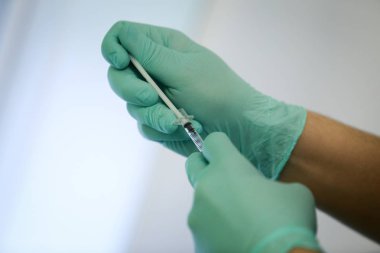 Plastik cerrahi eldiven giyiyor ve kan ve kan plazma bir şişe bir şırınga ile açılan bir doktor eliyle ayrıntıları