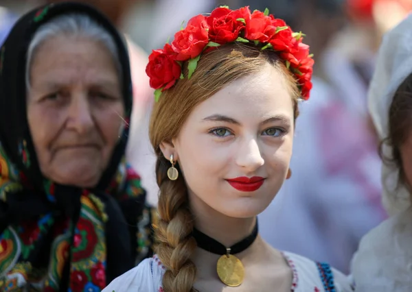 Όμορφη νεαρή γυναίκα (με τη γιαγιά της) φορώντας ένα λουλούδι που — Φωτογραφία Αρχείου