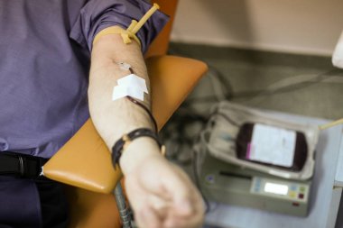 Kan bağışında olan bir adamın koluyla detaylar