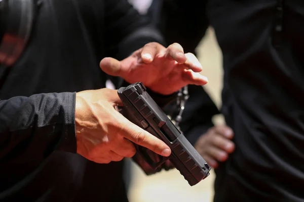 Details with the hands of a soldier handling a 9mm caliber Beret — Stock Photo, Image