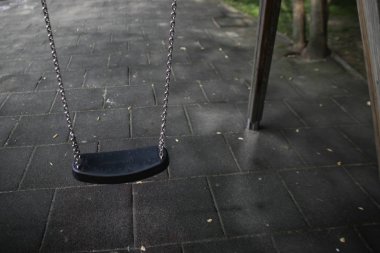 Etrafta kimse yokken çocuk parkında sallanan genç bir kız..