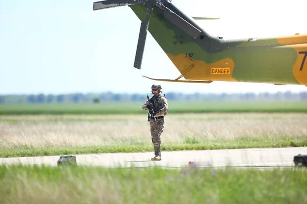 Un soldat de l'armée roumaine patrouille une base aérienne militaire, près d'une milita — Photo