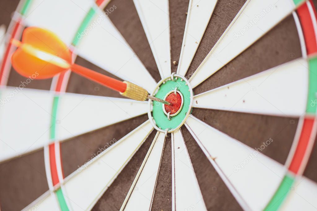 Close-up image with a dart in the bullseye of a practice target