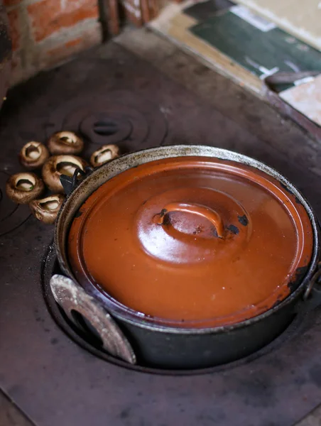 Panela de ferro fundido no fogão de madeira com cogumelos frescos no countr — Fotografia de Stock