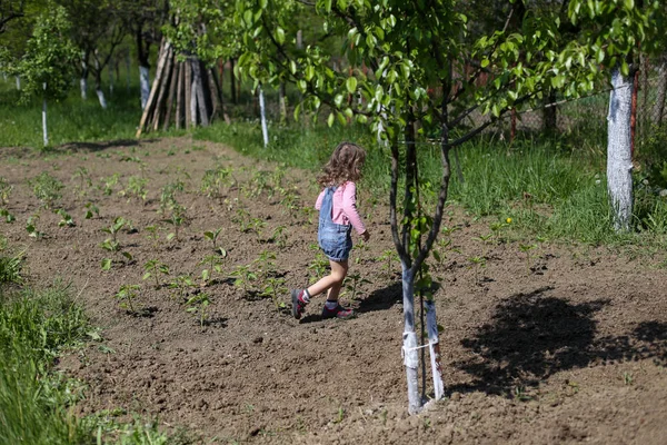 Small girl running on dirt on a farm in rural Romania