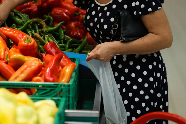 Uma mulher usa sacos de plástico biodegradável para comprar frutas e v — Fotografia de Stock