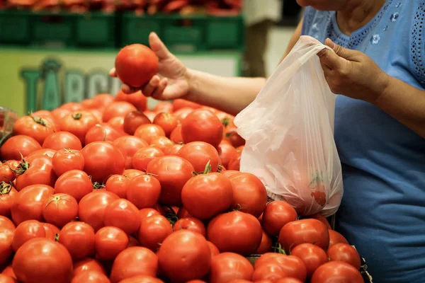 Uma mulher usa sacos de plástico biodegradável para comprar frutas e v — Fotografia de Stock