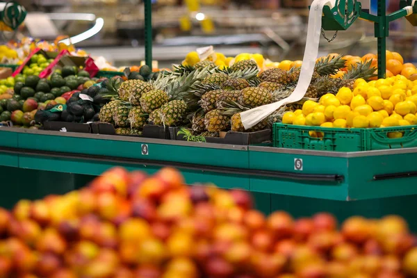 Piñas y limones en el pasillo de frutas y verduras en un st — Foto de Stock