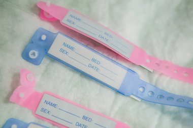 Close-up image with new born babies tags, blue for boys and pink clipart