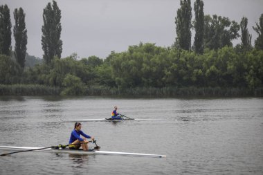 Snagov, Romanya - 18 Nisan 2020: Olimpiyat Takımı 'ndan Romen profesyonel kürekçiler bir spor sahasında antrenman yapıyorlar.